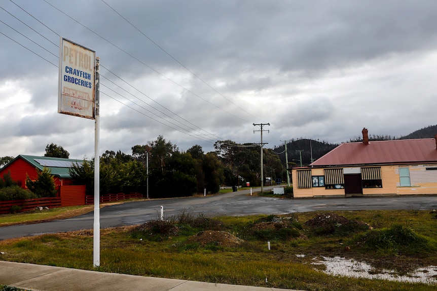 A faded petrol station sign next under a cloudy sky