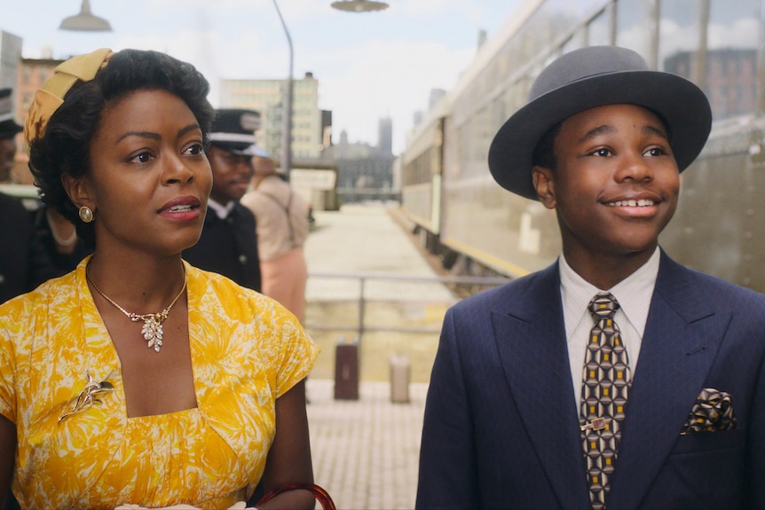 a woman in 1950s yello dress and young boy in blue suit and hat, playing emmett till and his mother in the film