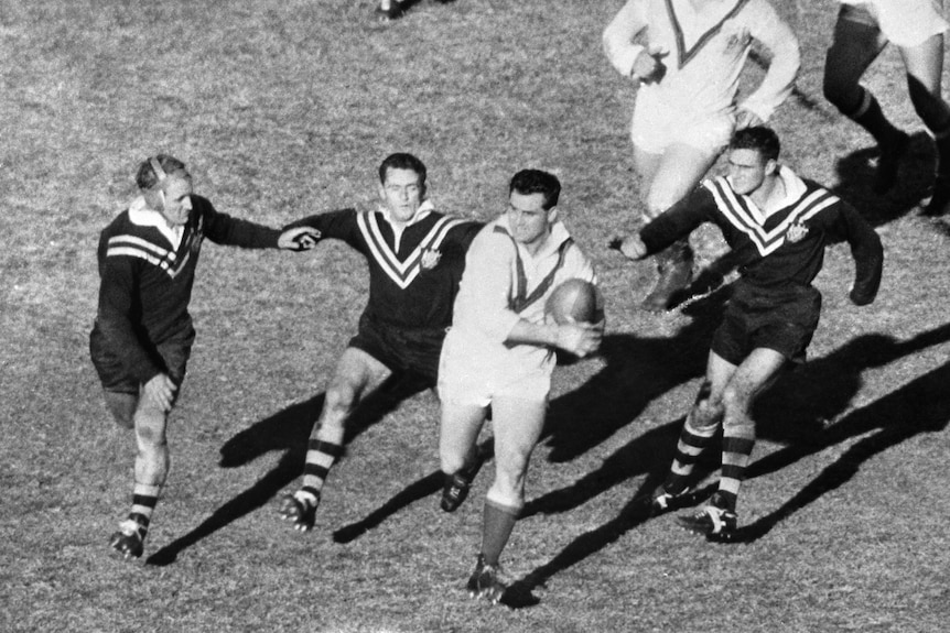 Derek Turner of Great Britain is chased by Kangaroos Johnny Raper, Barry Muir and Reg Gasnier during a rugby league Test.
