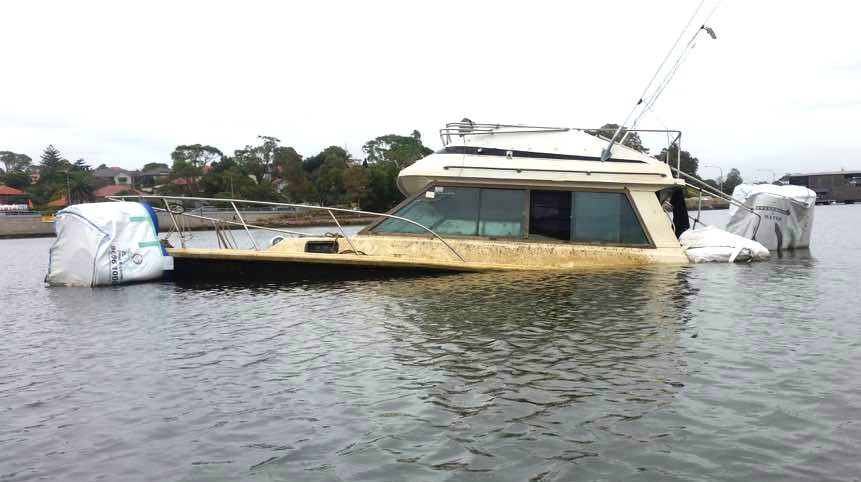 A derelict boat submerged in the water near Haberfield
