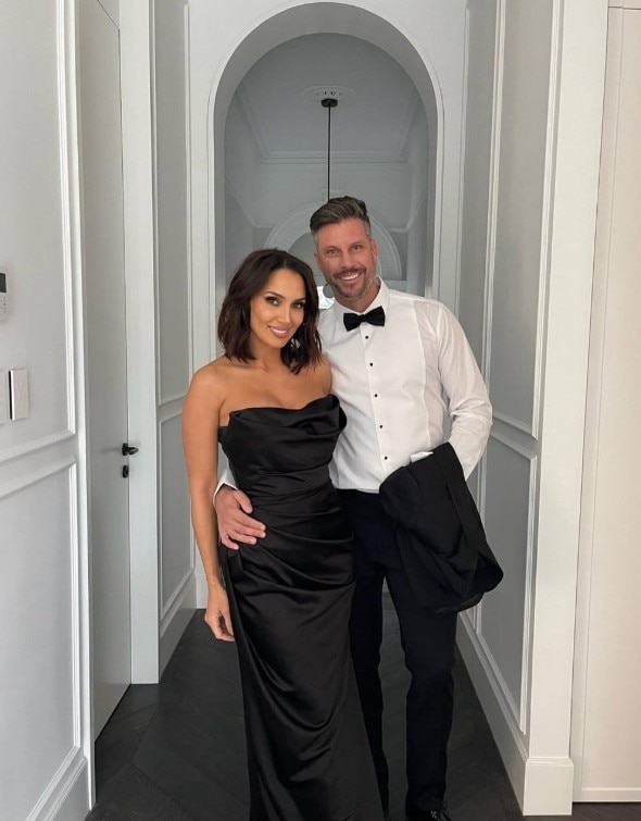 A man and woman wearing formal outfits and smiling
