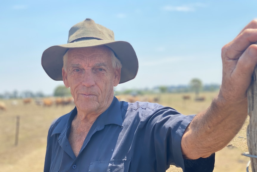 Farmer stands on very dry ground. 