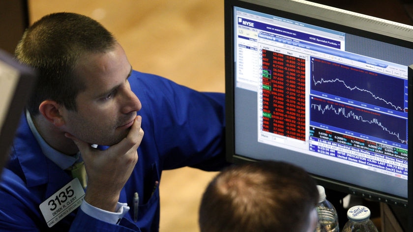 Traders work at the New York Stock Exchange staring at a computer screen.