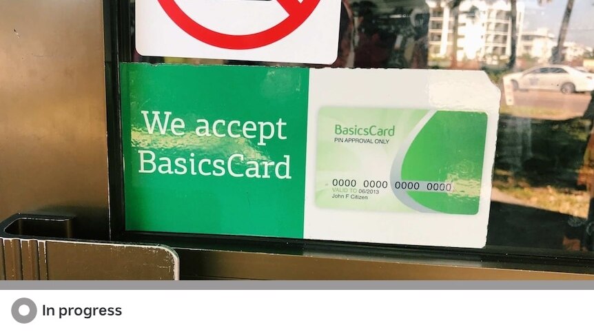 A large green coloured sign on a shop front which reads "We accept BasicsCard"