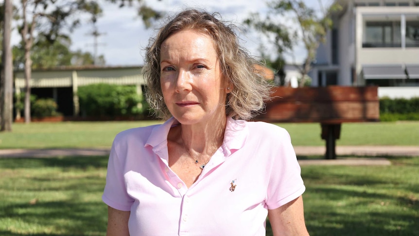 Michelle Snape sits in a park looking at the camera.