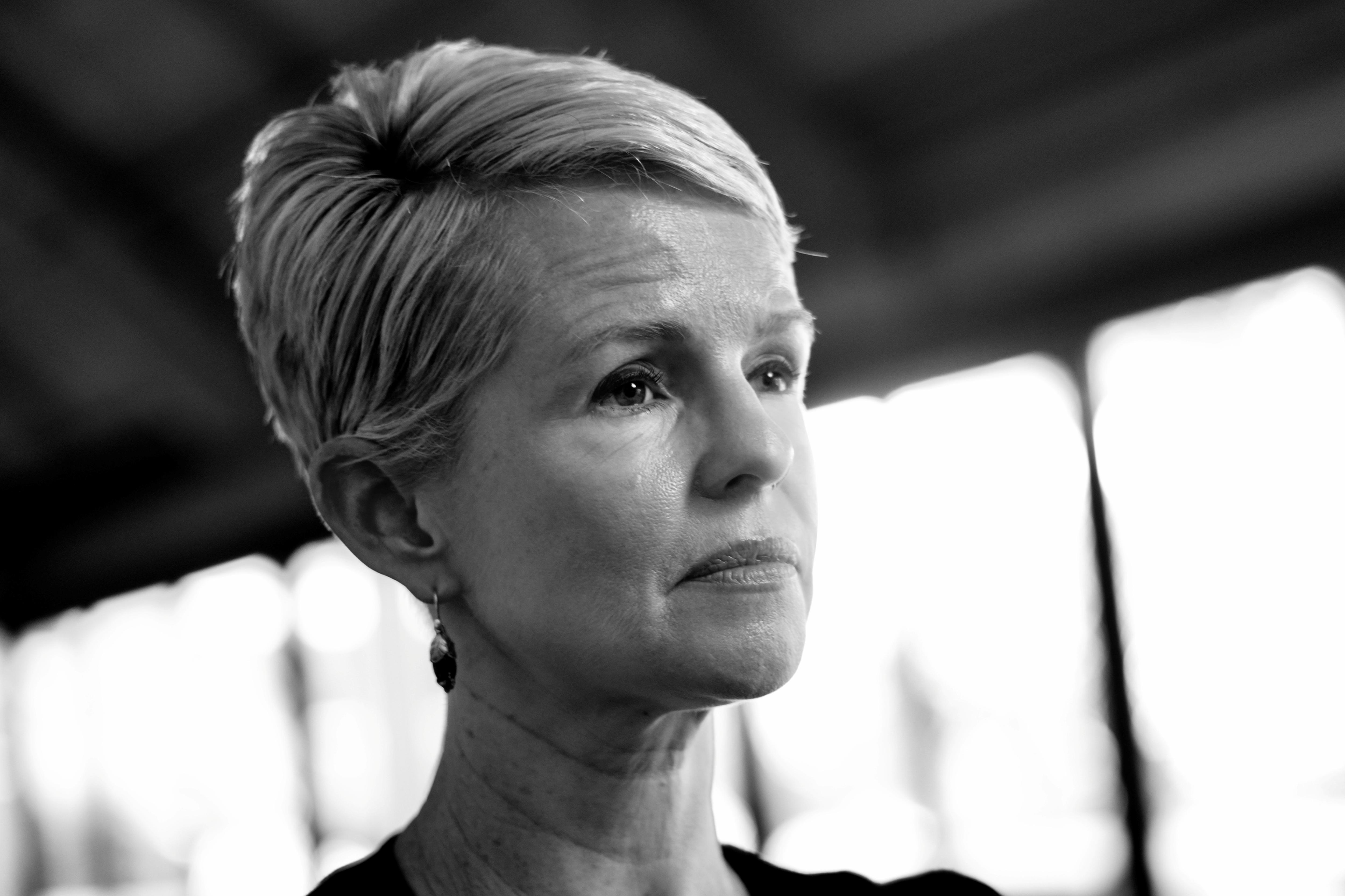 Un primer plano de una mujer con pelo corto mirando hacia adelante.