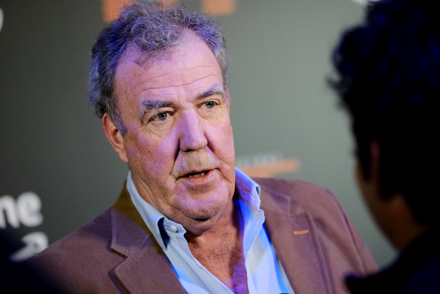 A close-up of Jeremy Clarkson speaking to an unidentified person who can be seen in front of him