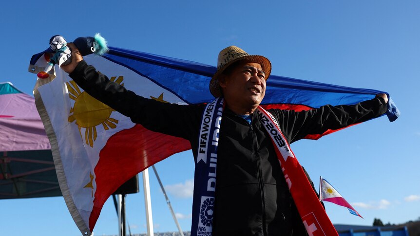 A Philippens supporter holds his nation's flag above his head.