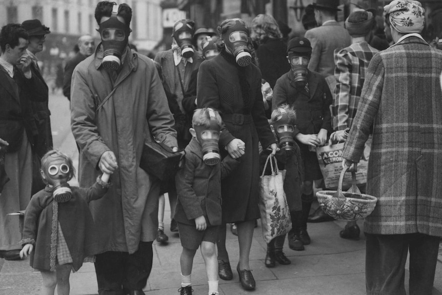 1914年英格兰防毒气攻击演习中，一家人戴防毒面具去购物。