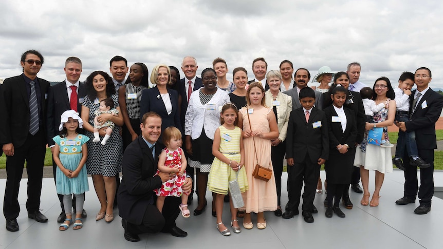 Malcolm Turnbull and his wife, Lucy, pose for a photo with new Australian citizens on the shores of Lake Burley Griffin.
