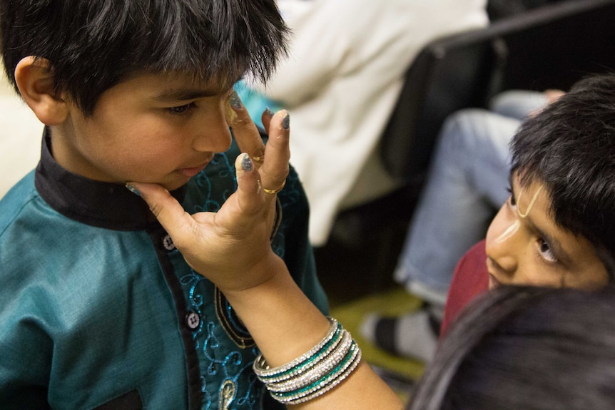 A boy is painted with the Tilak at the Hare Krishna temple.