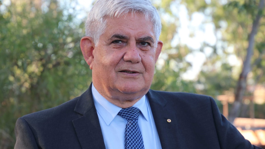 A head and shoulders shot of Liberal MP for Hasluck Ken Wyatt wearing a suit, shirt and tie outdoors.