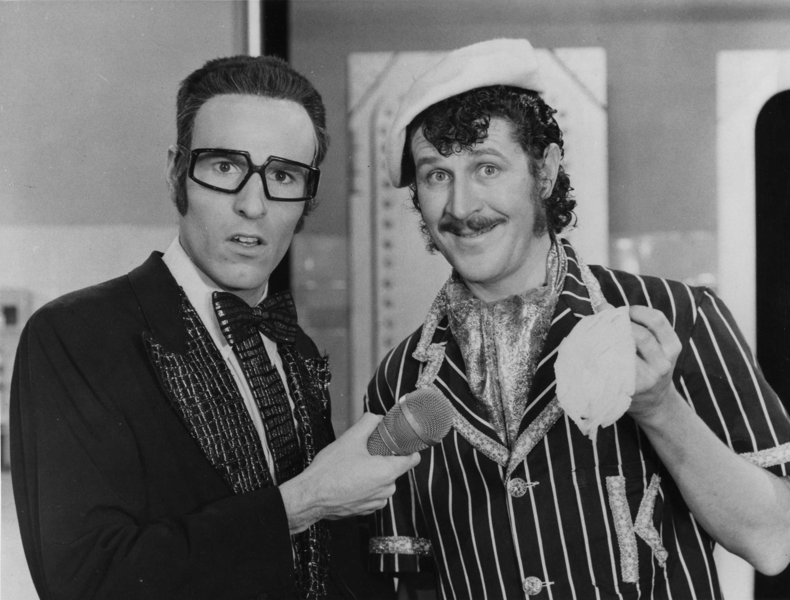 A black and white photo of Rory O'Donoghue and Grahame Bond in costumes on a TV set