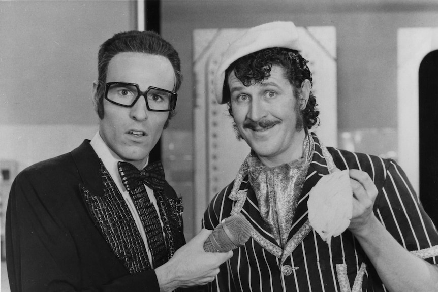 A black and white photo of Rory O'Donoghue and Grahame Bond in costumes on a TV set