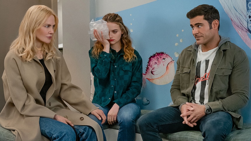 Nicole Kidman sits Joey King and Zac Efron in a doctor's waiting room, Joey with an ice pack to her face.
