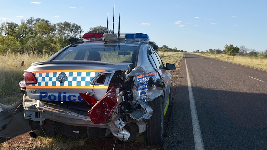 A police car sits on the side of a road after being rammed by a stolen car.