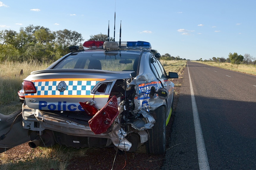 A police car sits on the side of the Stuart Highway after being rammed by a stolen car.