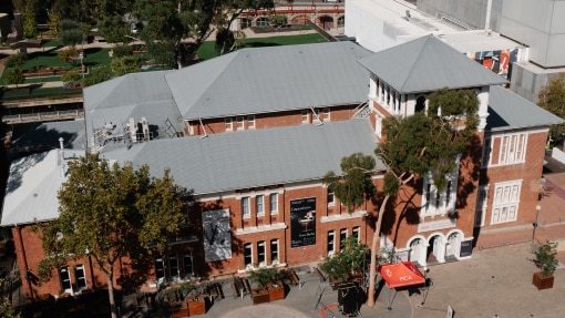 An aerial view of a large red-brick building with white trim.