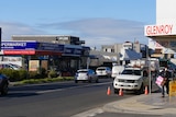 Cars drive up and down the suburban street of Glenroy on a sunny day.