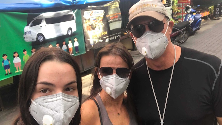Selfie of Evie, Sharon, and Karl Radonich wearing facemasks on a Chiang Mai street in Thailand