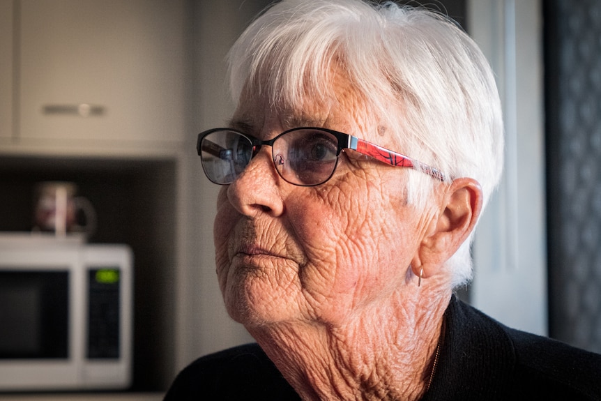 Yvonne Moss wearing glasses looks upwards.