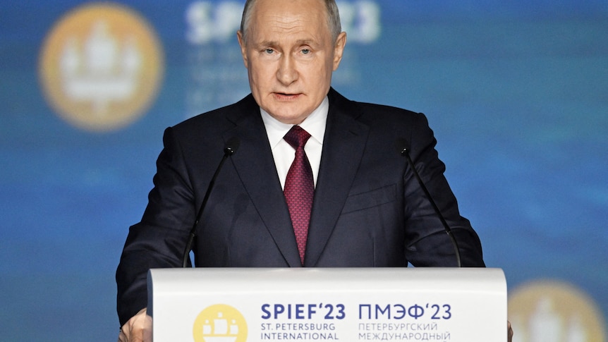Russian President Putin gives a speech in suit during a forum. 