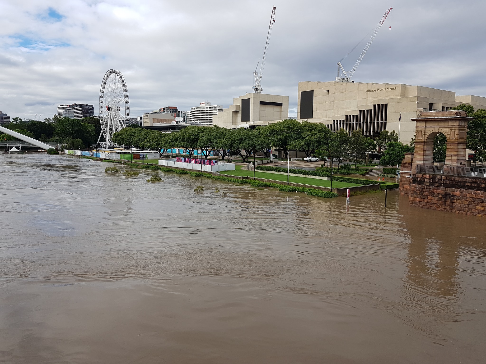 A swollen Brisbane River with Southbank in the background.
