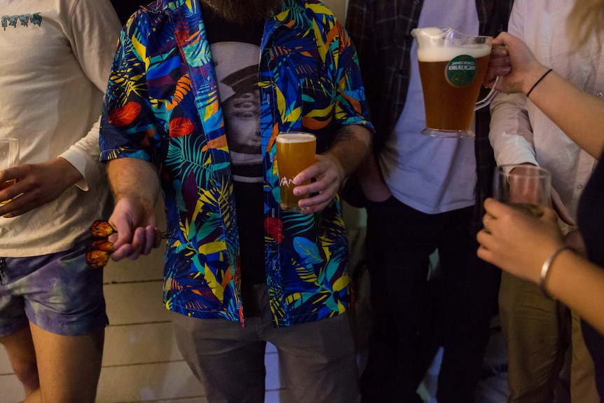 Beers and darts in hands, shorts and hawaiian shirts.