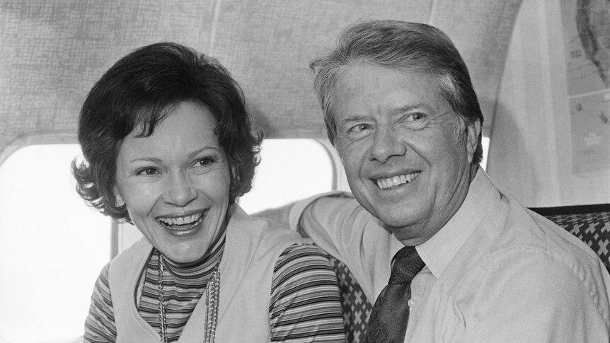 Former president Jimmy Carter and wife Rosalynn on a plane smiling