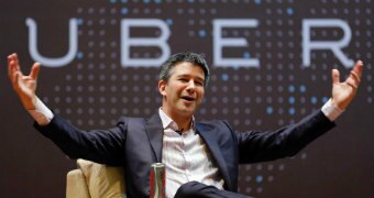 Travis Kalanick sits in front of the uber logo with his arms spread wide, open palmed drawing attention to the word UBER
