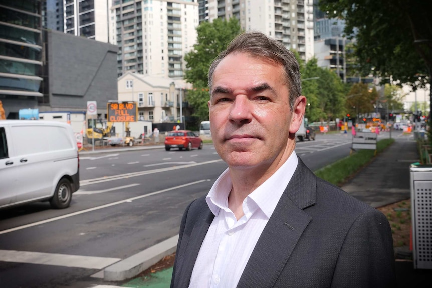 Adam Cockayne poses for a photo while standing in front of a road.