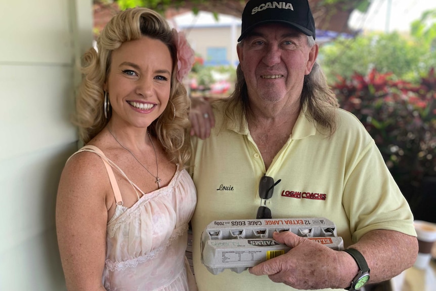 Canungra shop owner Krystal Turner on her daily egg give away standing beside grateful recipient local school bus driver Louie