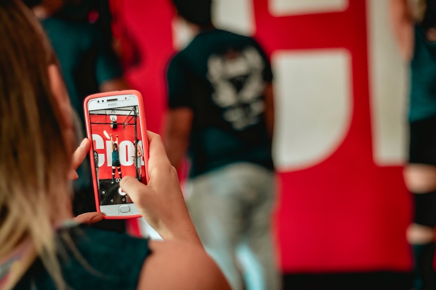 A woman filming another person with her smartphone