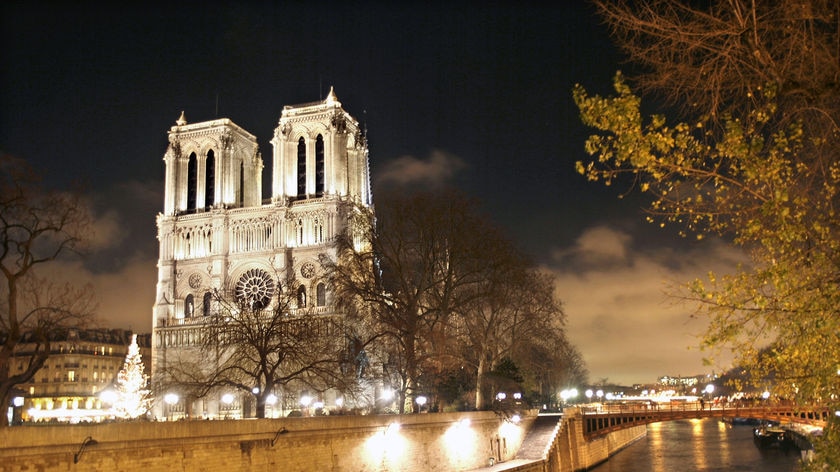 A view of Notre Dame cathedral, before it was damaged, lit up at night.