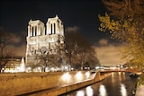 A view of Notre Dame cathedral, before it was damaged, lit up at night.