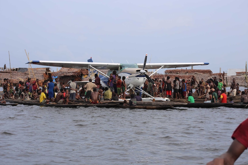 Float plan landed at floating village, surrounded by local residents.