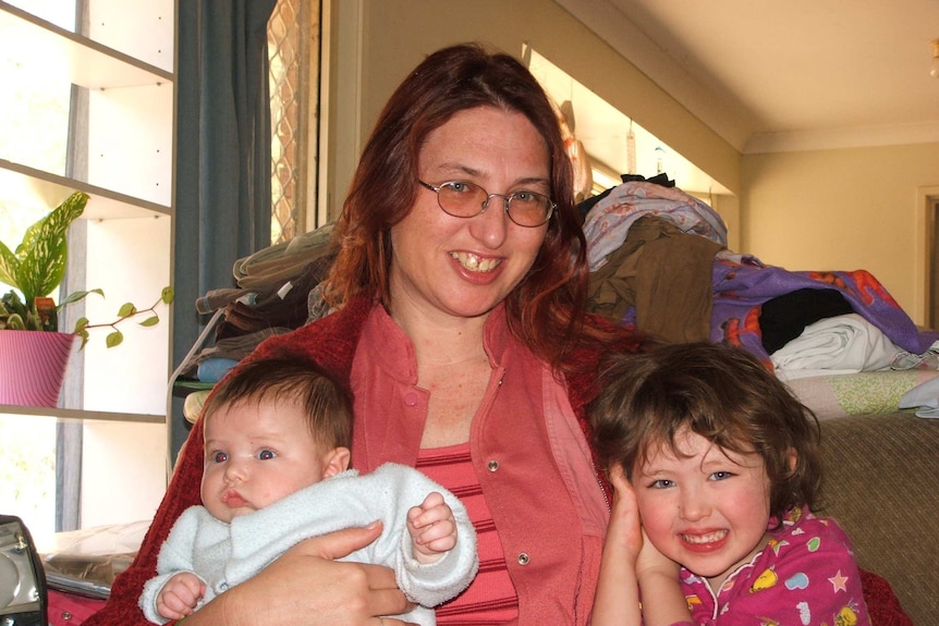 Yoshe Taylor holds a baby and a young girl.