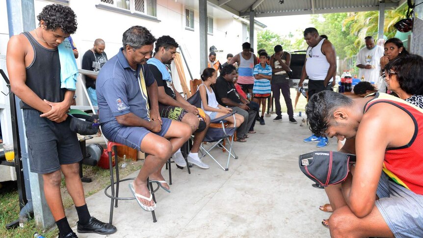 Members of Logan's Aboriginal community pray at the scene of a weekend brawl