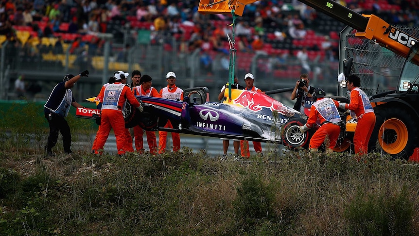 Mark Webber's car is airlifted off the track after it caught fire at the Korean grand prix.