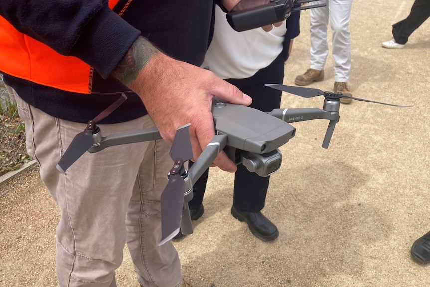 A person holds a small drone.