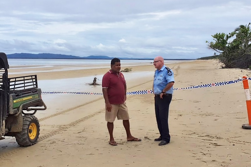 Lockhart River Mayor Wayne Butcher speaks with Police Inspector Mark Henderson on a beach.