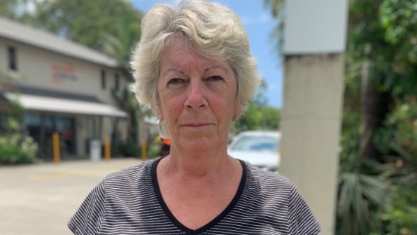 A woman in a striped shirt looked at the camera outside the caravan park