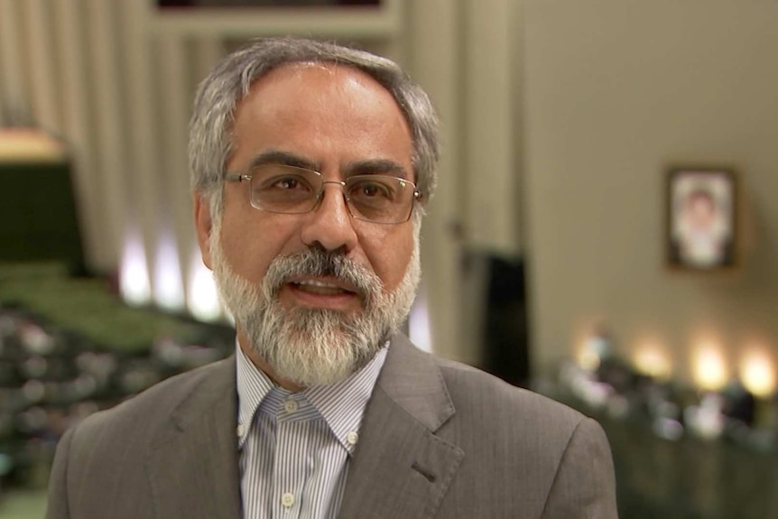 Kamal Dehghani Firouzabadi with grey hair, white beard and glasses.