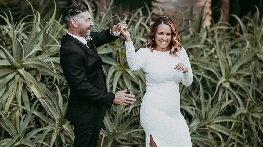 Jacci D'Mellow (right) is twirled by her husband on their wedding day.