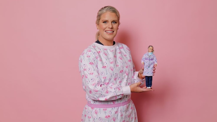 Doctor Kirby White holds one of the Barbie dolls that looks like her