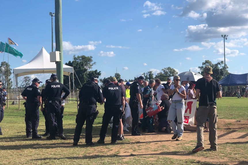 Police and members of public standing in Clermont showgrounds