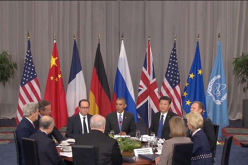 US President Barack Obama sits at a round table with representatives from a number of countries