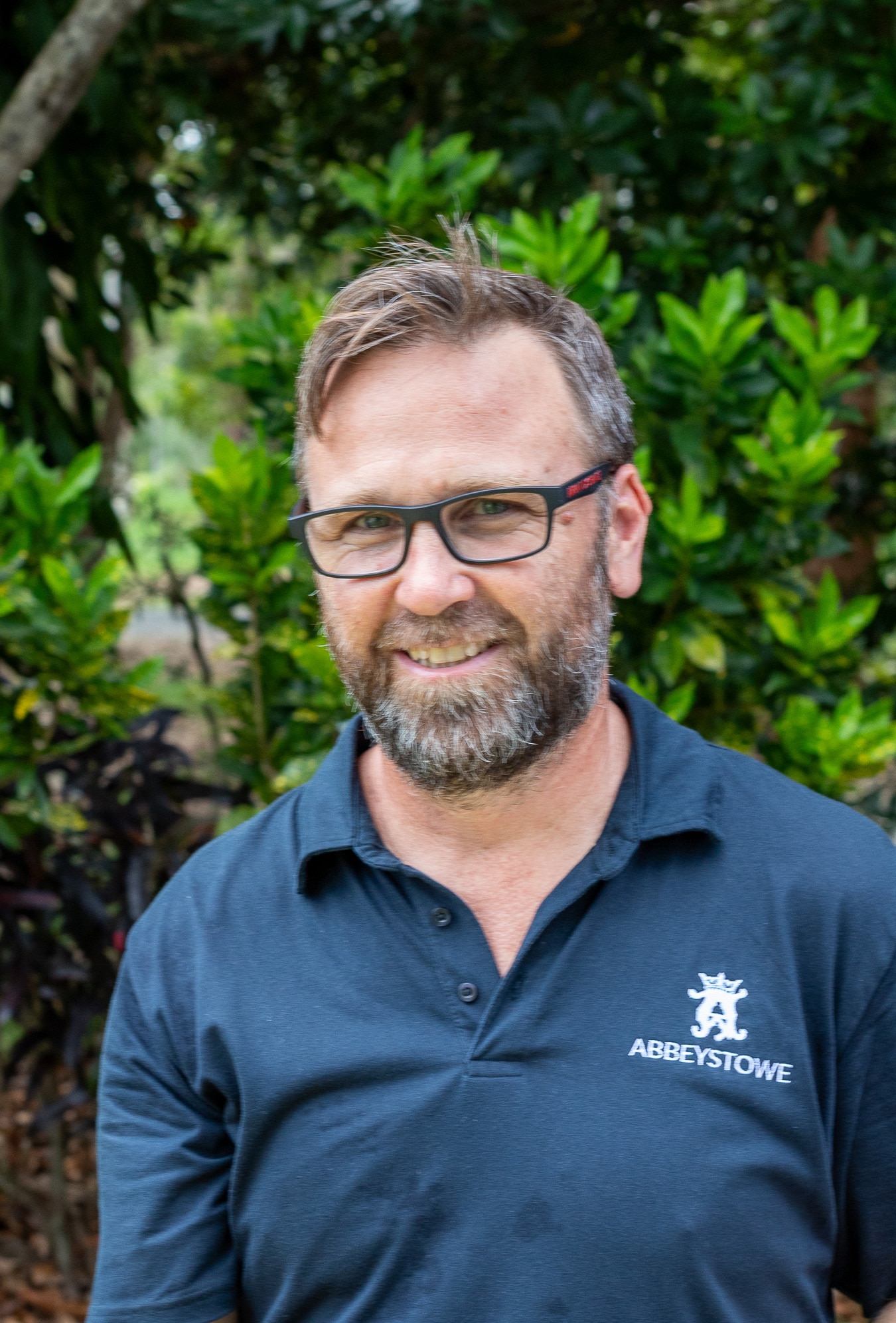 Um homem com barba e óculos vestindo uma camiseta que diz 