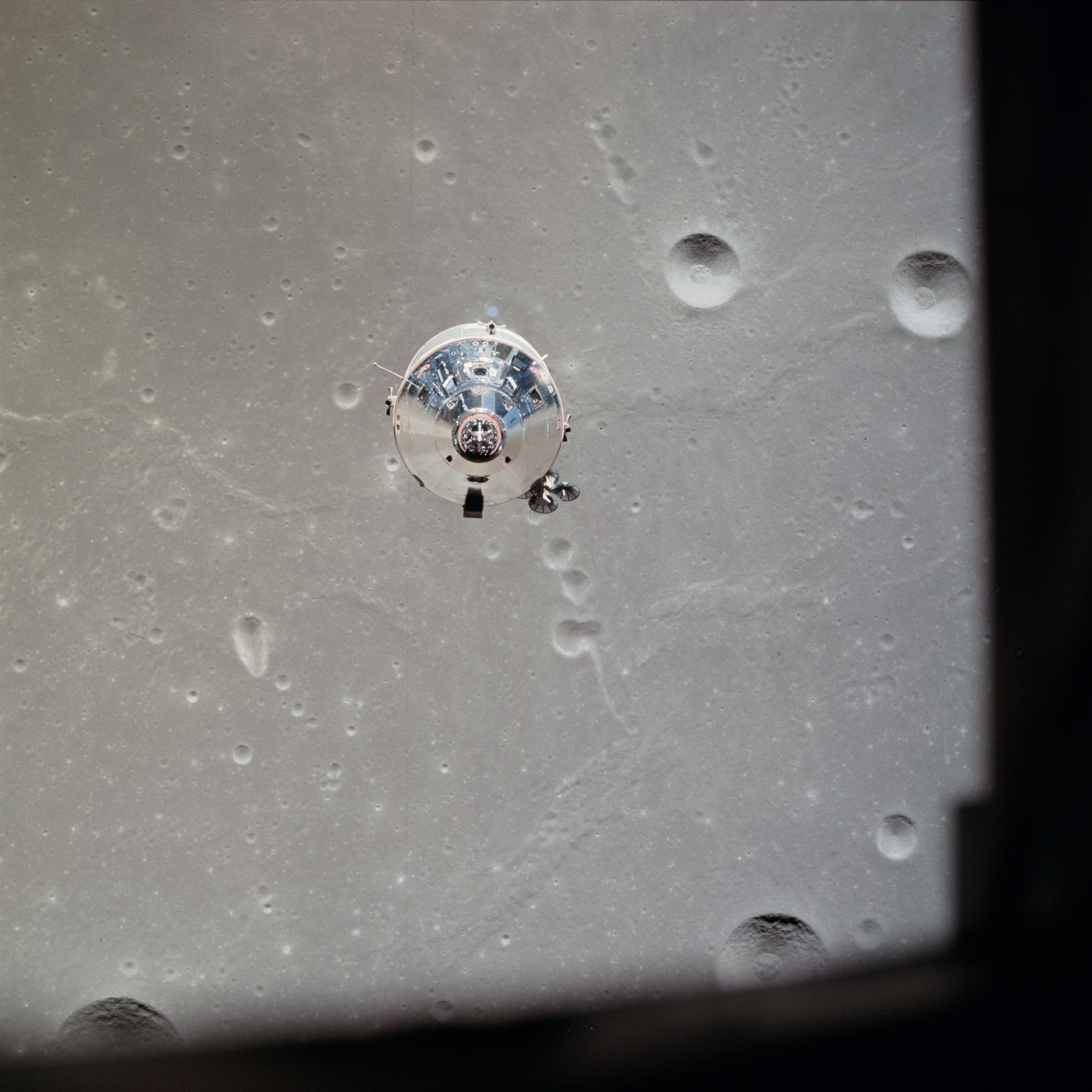 A spacecraft floats above the surface of the Moon.