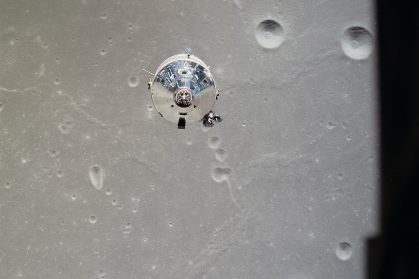 A spacecraft floats above the surface of the Moon.